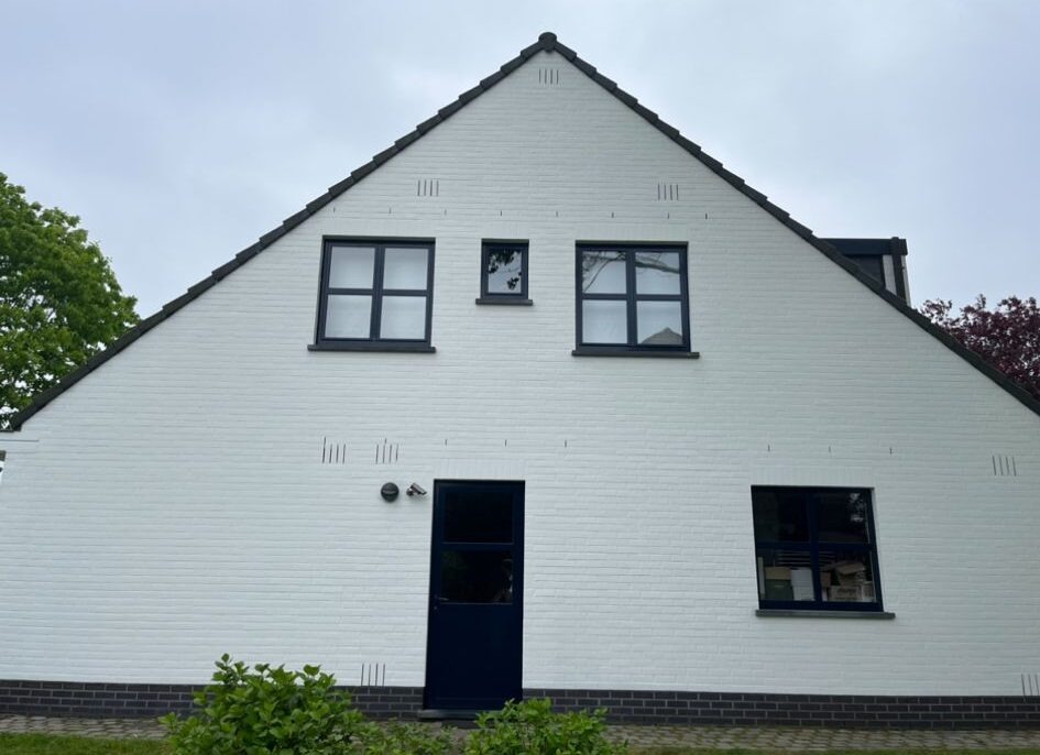 vakman brengt dunne kalei aan met een blokkwast