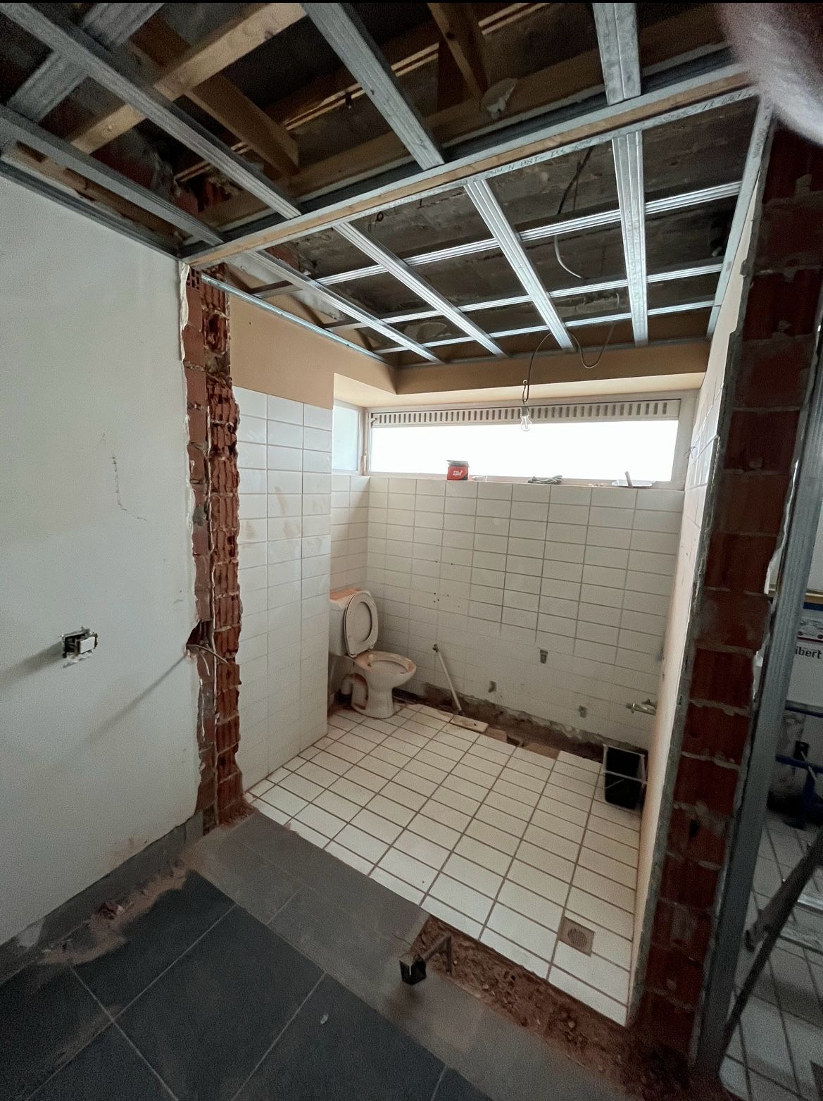 Schroefstempels onder een houten balkenvloer in een herenhuis in Aalst voor het slopen van een draagmuur