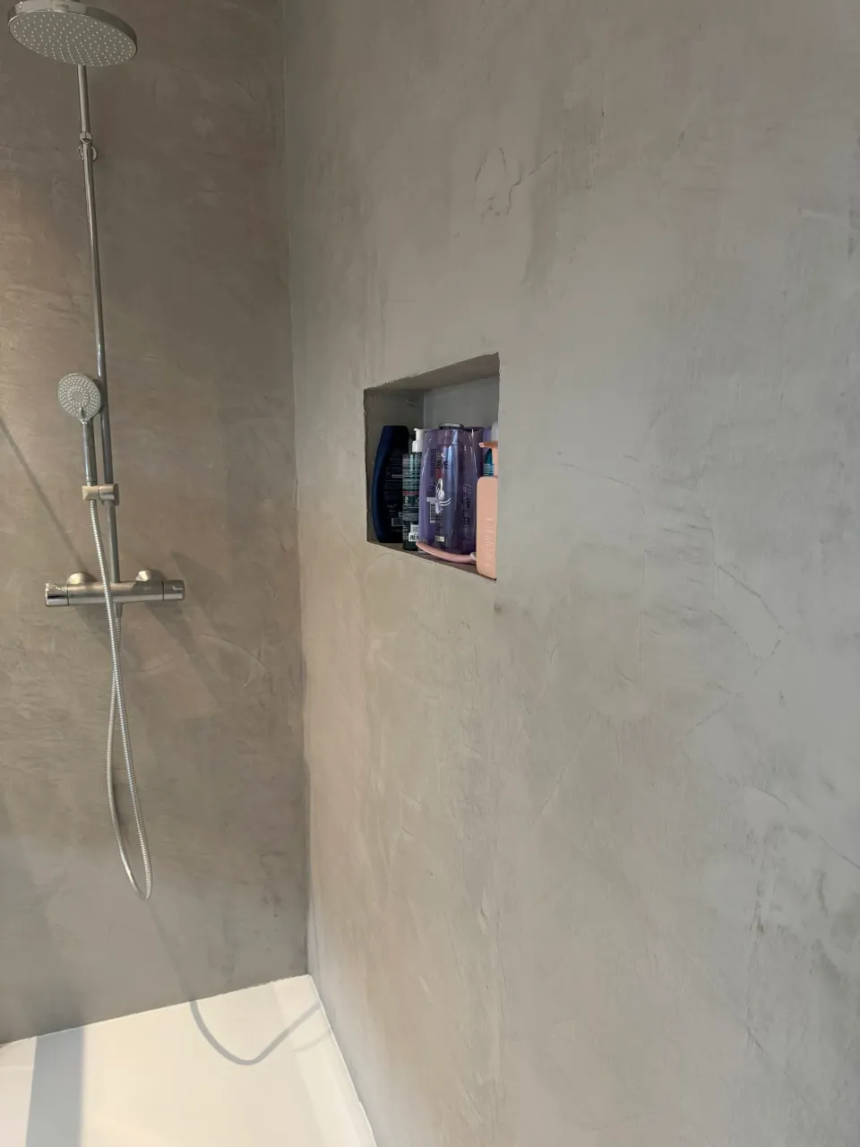 Naadloze betonlook douchewand met ingebouwde nis