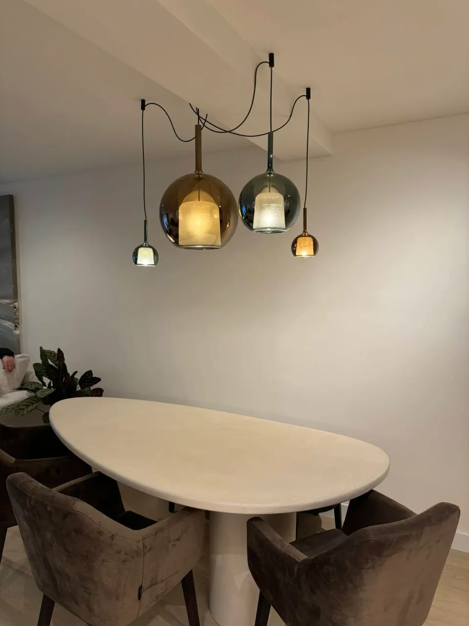 Betonlook muur met hanglampen boven de eettafel