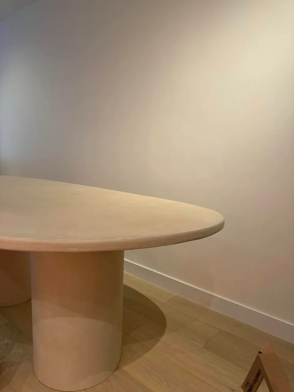 Betonlook wand in een eetruimte met ronde tafel